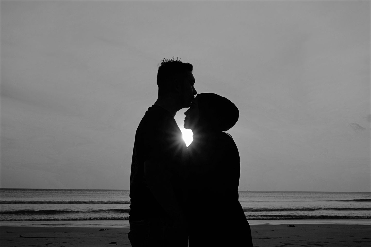 May be a black-and-white image of 2 people, ocean and beach