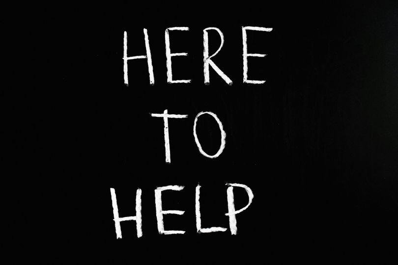 May be a black-and-white image of text that says 'HERE TO HELP'